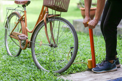 Low section of man riding bicycle on field