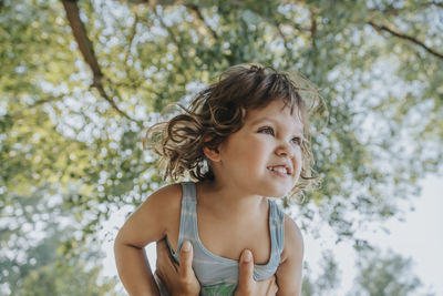 Daughter looking away while mother picking up in air