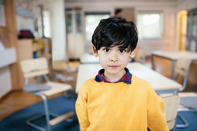 Portrait of boy standing in classroom