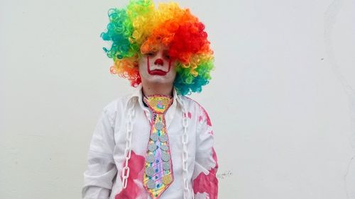 Close-up portrait of boy wearing costume standing against wall