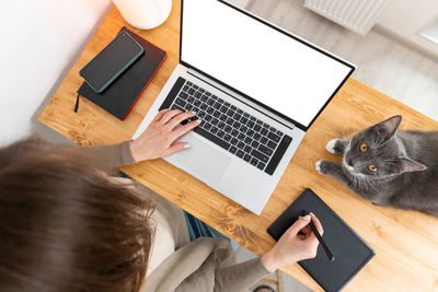 Unrecognizable woman working at laptop. female freelancer drawing or retouching on graphic tablet.