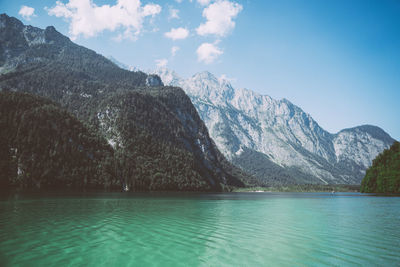 Scenic view of lake by mountains against sky