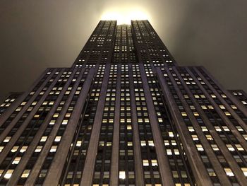 Low angle view of illuminated buildings against sky at night