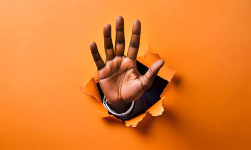 Close-up of human hand against yellow background