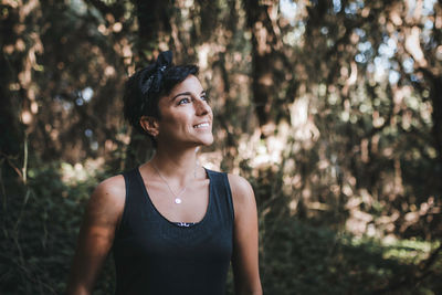 Portrait of young woman looking away in forest