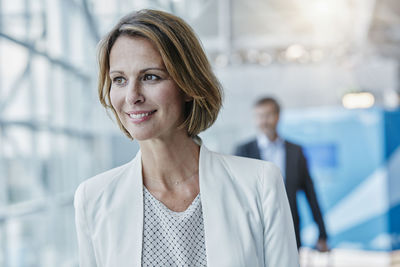 Smiling businesswoman at the airport looking sideways