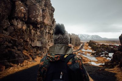 Rear view of woman standing at pingvellir national park during winter