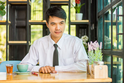 Portrait of man sitting on table