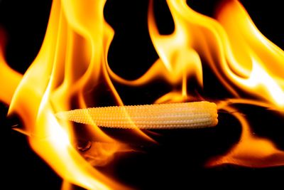 Close-up of lit candle against black background