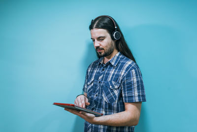 Portrait of a young businessman with tablet and headphones on a