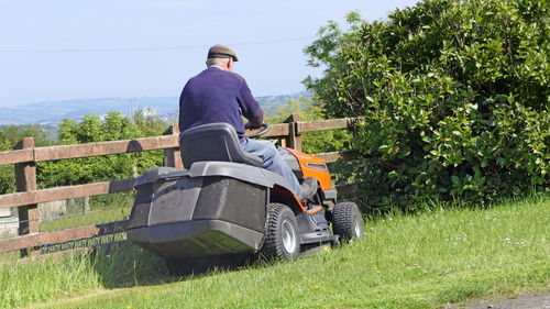 Rear view of man sitting on field