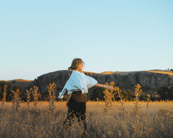 Woman on field against clear sky