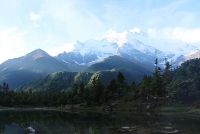 Scenic view of river and mountains against sky on sunny day