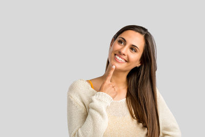 Portrait of a smiling young woman against white background