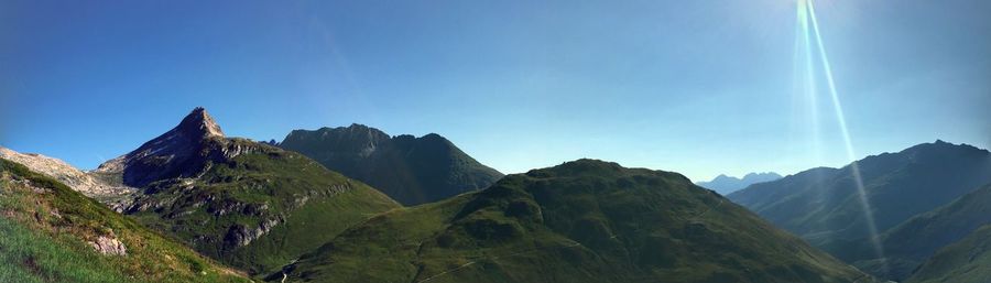 Panoramic view of mountains against clear blue sky