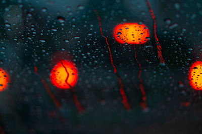 Close-up of wet red car windshield during rainy season