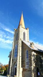 Low angle view of bell tower against blue sky