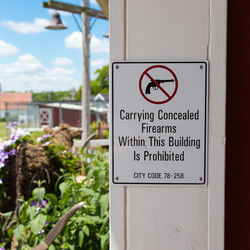 Warning sign board mounted on wall at entrance