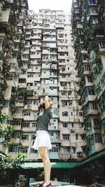 Full length rear view of woman walking in city buildings