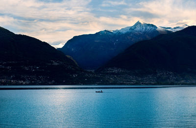 Scenic view of lake by mountains against sky