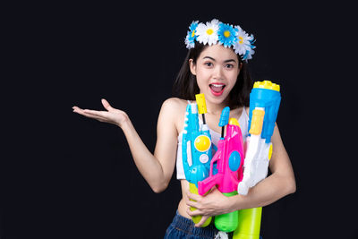 Portrait of a smiling young woman against black background