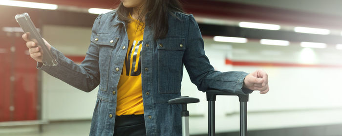 Midsection of woman holding mobile phone