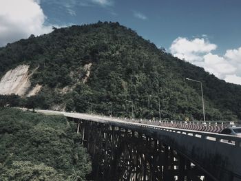 Bridge over mountain against sky