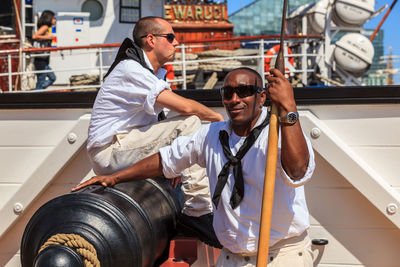 Portrait of man holding camera while standing on boat