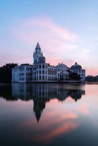 Reflection of building in lake against sky