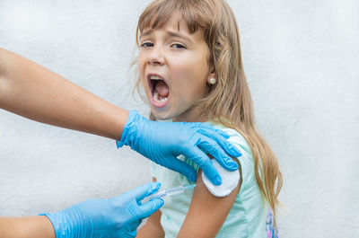 Close-up of young woman with hands against white background