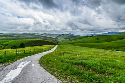 Empty road along countryside landscape