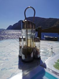Close-up of wine glass on table against sea
