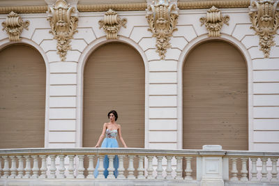 Full length of woman standing against building