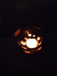 Close-up of lit candle in dark room