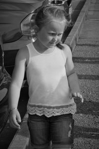 Cute girl looking down while standing outdoors