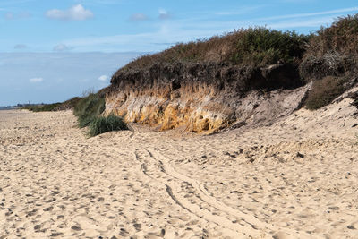 Sand dune on beach against sky