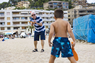 Grandpa and grandson playing on the beach