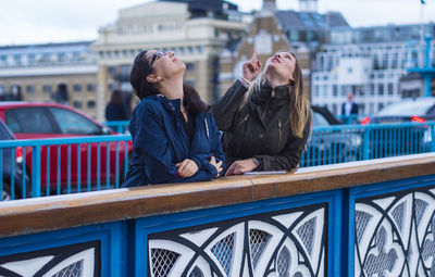 People on railing in city