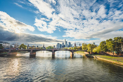 Bridge over river against buildings in city