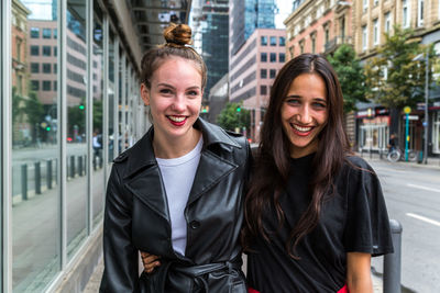 Portrait of smiling young women in city