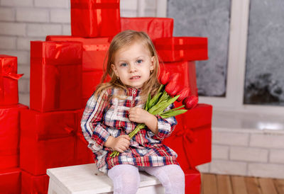 Funny surprised little girl with flowers. happy birthday gift.