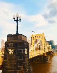 Low angle view of bridge over river against buildings