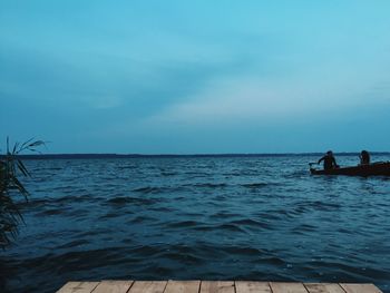 Men in sea against sky