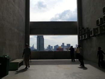 People walking in city against sky