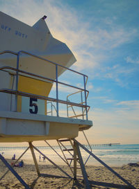 Low angle view of lifeguard hut at beach against sky