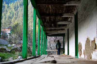 Rear view of man standing under bridge