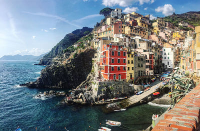 Buildings by sea against sky