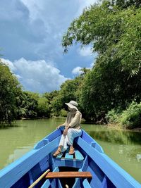 Full length of woman sitting on boat in river