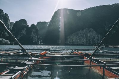 Boats moored in sea against mountain