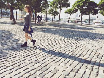 Full length of woman standing on footpath